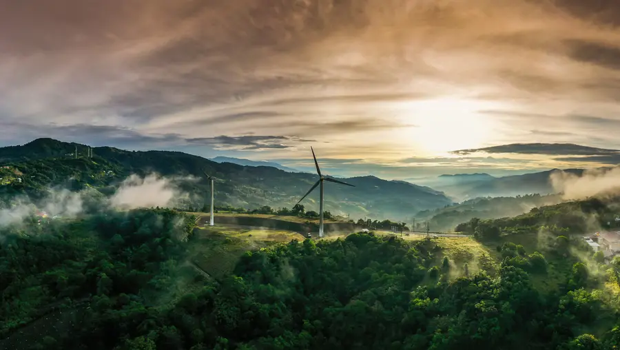 green landscape showing wind turbine with sky in background